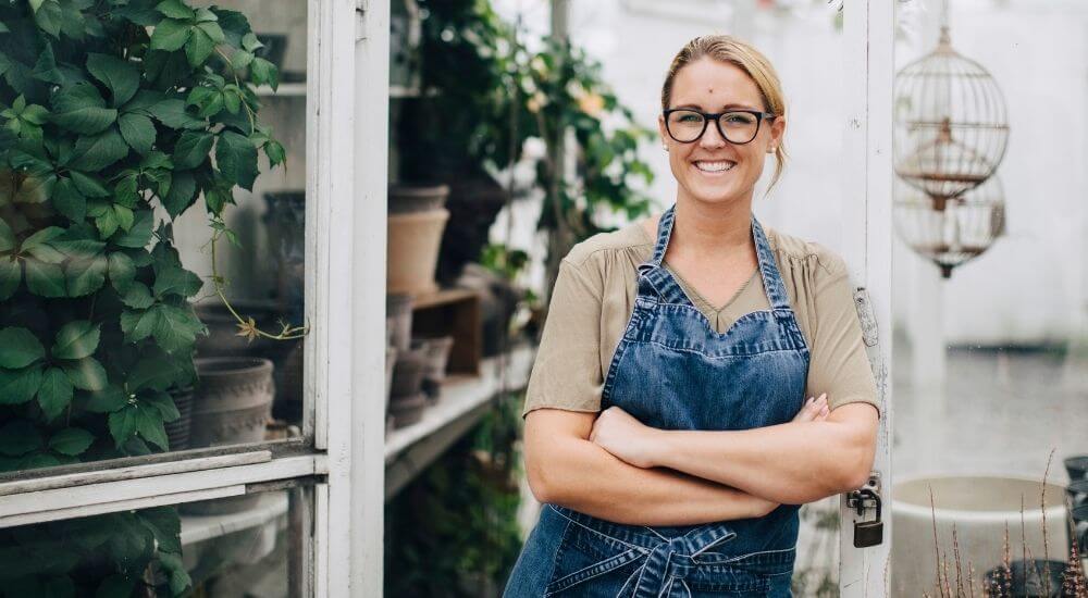 Young female business owner standing in a greenhouse